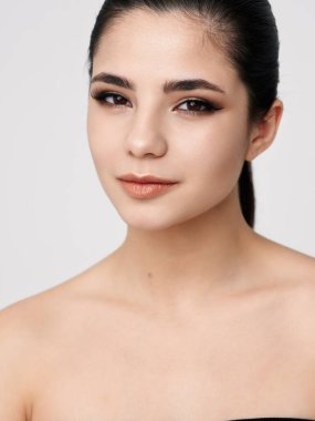 Esmer, açık tenli, çıplak omuzlu çekici bir görünüş.