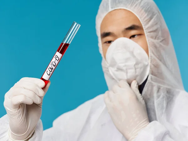 A man of Asian appearance holds a biotechnology research coronavirus blood test — Stock Photo, Image