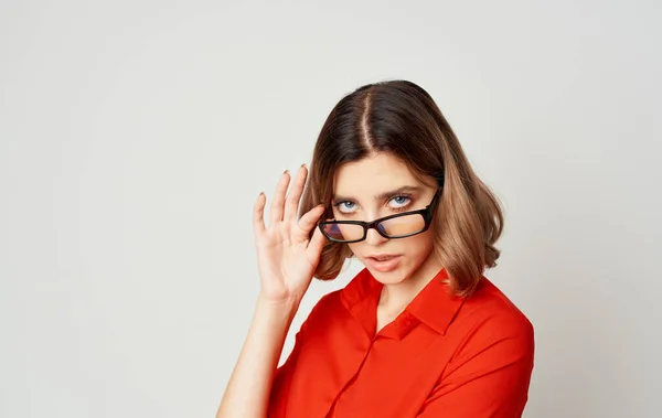 Mujer de negocios de confianza en una camisa roja y gafas emociones de fondo beige —  Fotos de Stock