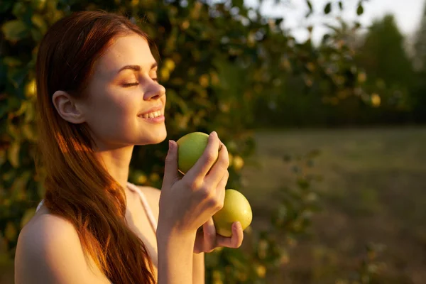 Mujer feliz con manzanas en sus manos en la naturaleza verdes árboles de hierba sol de verano — Foto de Stock