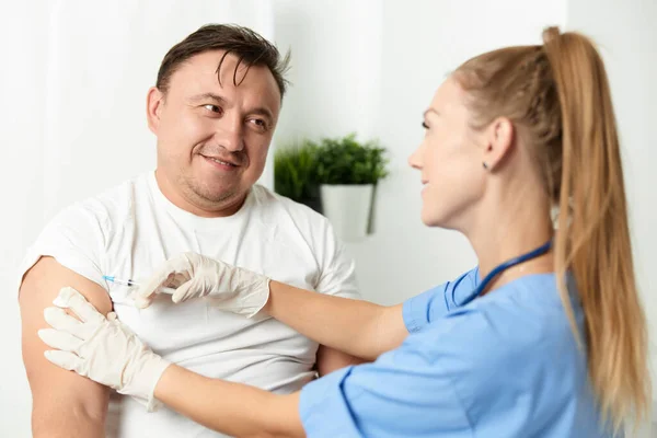 Doente do sexo masculino hospitalizado ao lado do médico vacinação por injecção — Fotografia de Stock