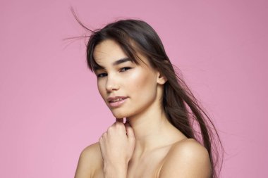 Esmer, çıplak omuzlar, temiz cilt bakımı pembe arka plan.