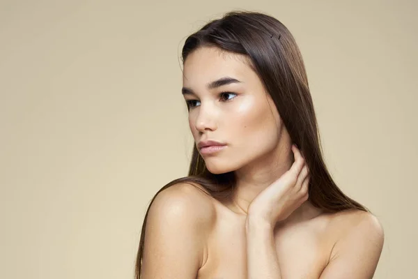 Hübsche Frau nackte Schultern Kosmetik saubere Haut Haarpflege beige Hintergrund — Stockfoto