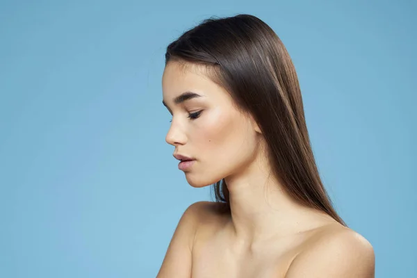 Mulher bonita ombros nus cuidados com o cabelo close-up banco azul fundo — Fotografia de Stock