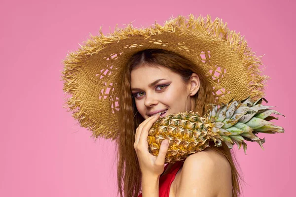 戴着草帽拿着枪的女人浓妆艳抹异国情调的水果夏日粉色背景 — 图库照片