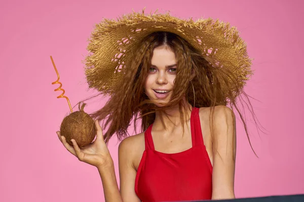 Kobieta z koktajlem kokosowym w słomkowym kapeluszu egzotyczne wakacje lato różowy tło — Zdjęcie stockowe