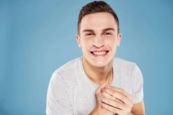 Cute emotional man in white t-shirt gesture with hands blue background — Stock Photo, Image