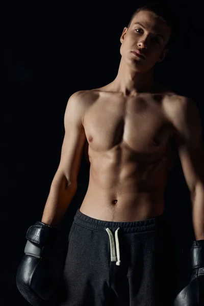 Testépítők boksz kesztyű fekete háttér és szürke nadrág sportoló modell — Stock Fotó