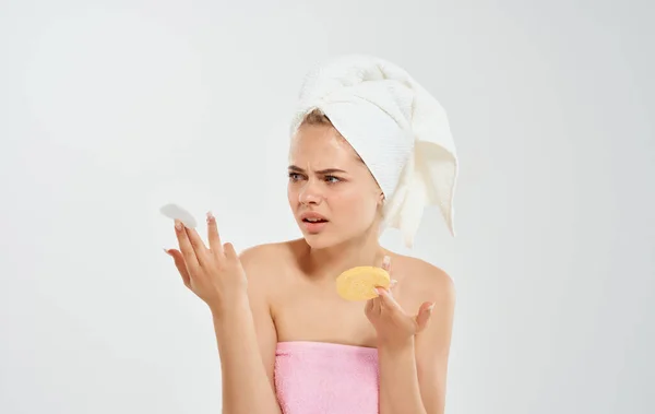 Femme avec une serviette sur la tête tient une éponge dans sa main cosmétologie dermatologie modèle — Photo