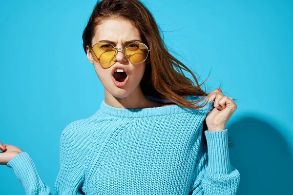 파란 스웨터를 입은 감정적 인 여성, 노란 안경을 쓰고 생활하는 모습 — 스톡 사진