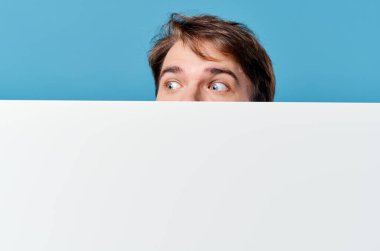 Pankartın arkasından bakan adam kırpılmış görüntü reklam alanı fotokopisi mavi arkaplan
