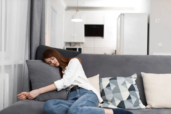 Kvinna bekvämt bosatte sig på soffan i lägenheten — Stockfoto