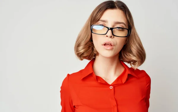 Mulher de negócios confiante em uma camisa vermelha e óculos emoções fundo bege — Fotografia de Stock