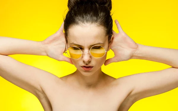 Brünette mit nackten Schultern gelbe Brille Emotionen isoliert Hintergrund — Stockfoto