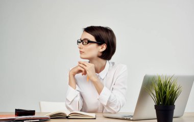 Dizüstü bilgisayarın önünde oturan bir kadın finans müdürü.