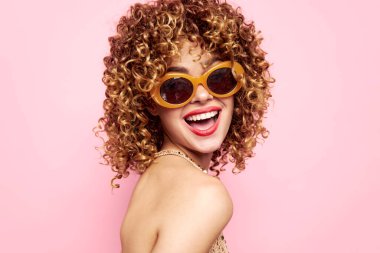 Kadın portresi kıvırcık saçlar, gülümse kırmızı dudaklar moda gözlükler stüdyosu. 