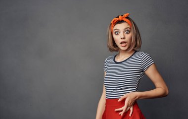 Çizgili tişörtlü güzel bir kadın. Kafasında turuncu bir bandaj var.