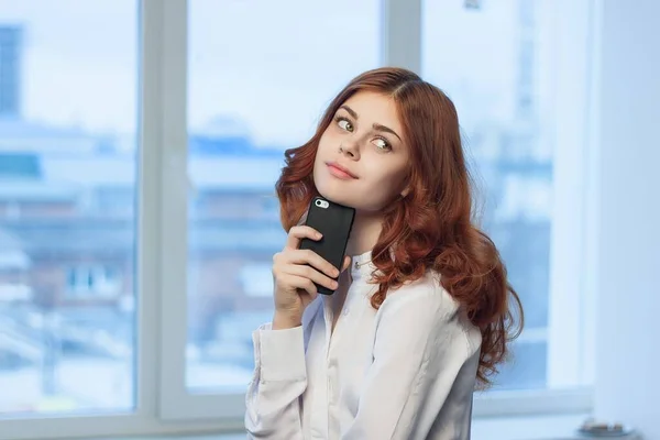 Hübsche Frau im Hemd mit Handy in der Hand — Stockfoto