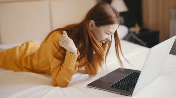 Emotionele vrouw liggend in bed in de voorkant van laptop internet technologie communicatie werk — Stockfoto