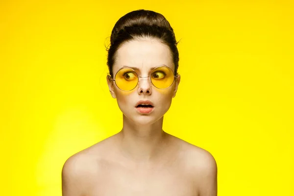 Brunette with bare shoulders yellow glasses emotions isolated background — Stock Photo, Image