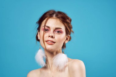 Güzel bir kadın çıplak omuzlu kozmetik küpeler lüks mavi arka plan