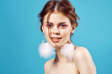 Güzel bir kadın çıplak omuzlu kozmetik küpeler lüks mavi arka plan