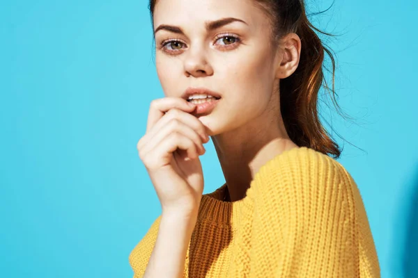 Bonita mujer en suéter amarillo atractivo look emociones close-up fondo azul —  Fotos de Stock