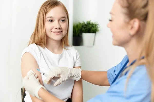 Kobieta lekarz daje dziewczynie zastrzyk w ramię medycyny zdrowia covid szczepienie — Zdjęcie stockowe