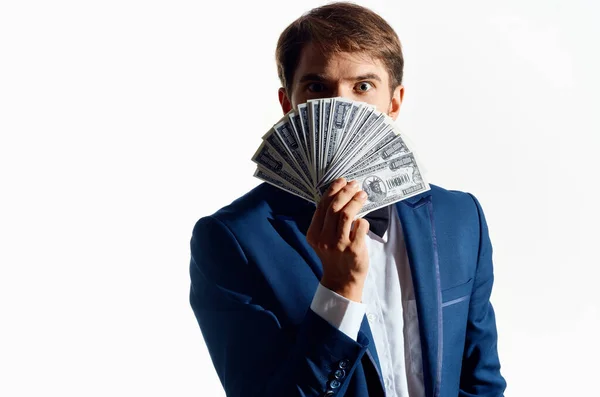 Hombre rico con un paquete de dinero en la mano y un traje clásico sobre un fondo blanco —  Fotos de Stock