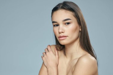 Çıplak omuzlu bir kadın çekici görünüyor. Açık tenli.