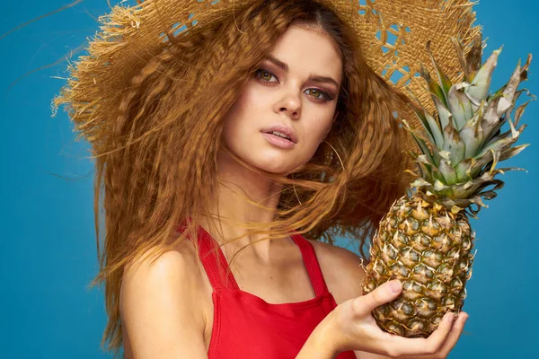 En kvinna i halmhatt med en ananas i händerna eller är det en rolig blå exotisk frukt bakgrund — Stockfoto