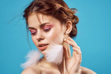 Güzel bir kadın, göz kamaştırıcı çıplak omuzlar, lüks, yakın plan mavi küpeler.