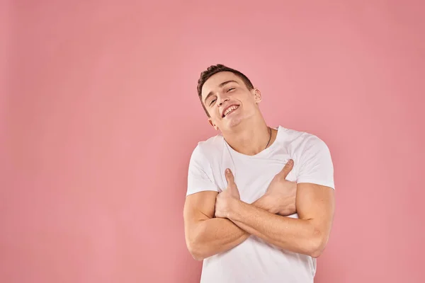 하얀 티셔츠 핑크 색 배경을 손으로 만지고 있는 감정적 인 남자 — 스톡 사진