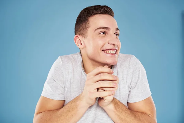 Cute emotional man in white t-shirt gesture with hands blue background — Stock Photo, Image