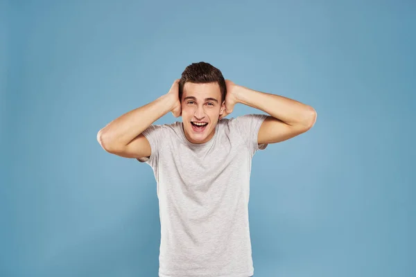 Cheerful man in a white t-shirt gesturing with his hands emotions blue background — Stock Photo, Image