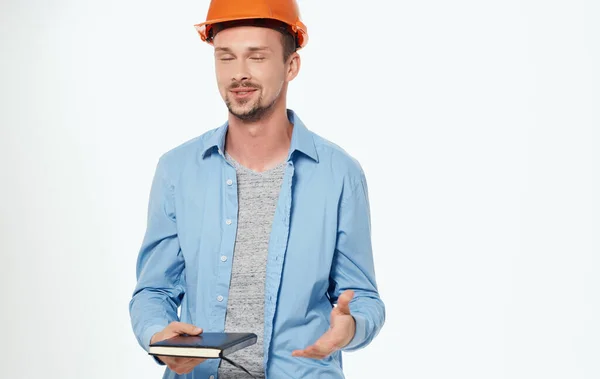 Mannelijke architect in oranje harde hoed werken grijze achtergrond bijgesneden uitzicht — Stockfoto