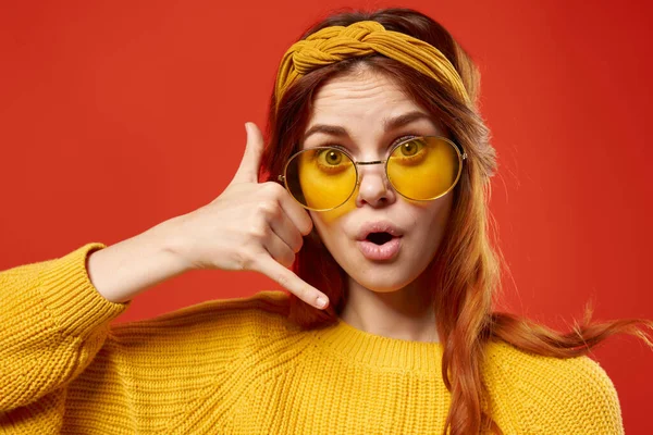 Alegre mujer emocional con gafas suéter amarillo primer plano fondo rojo — Foto de Stock