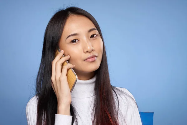 Csinos barna beszél a telefon fehér pulóver stúdió közelkép — Stock Fotó