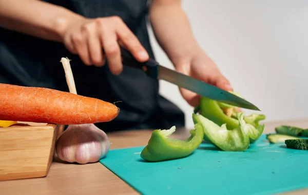 Cucina cibo sano cucina grembiule nero taglio verdure — Foto Stock