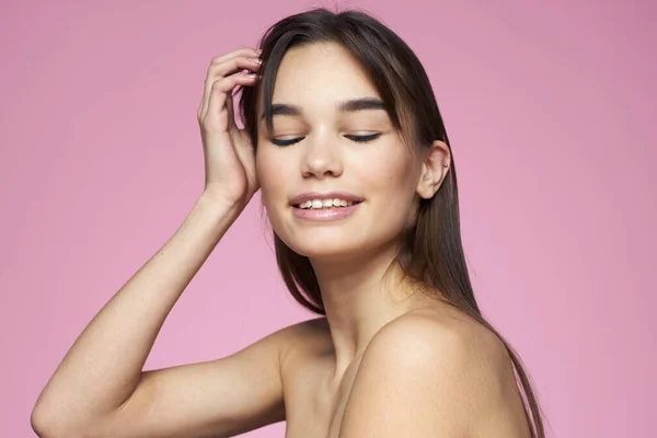 Frau mit nackten Schultern Haarpflege Make-up saubere Haut rosa Hintergrund — Stockfoto