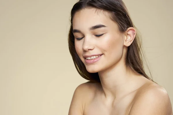 Bella donna spalle nude capelli lunghi cura del corpo sfondo beige — Foto Stock