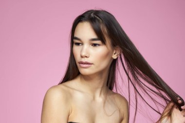 Esmer, çıplak omuzlar, temiz cilt bakımı pembe arka plan.