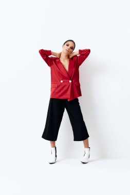 Kırmızı ceketli, parlak kozmetik elbiseli, şık arka planlı bir kadın.