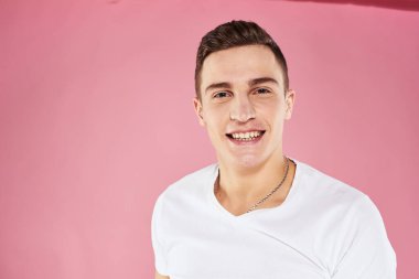 Beyaz tişörtlü bir adam elleri ve duyguları ile jestler yapıyor.