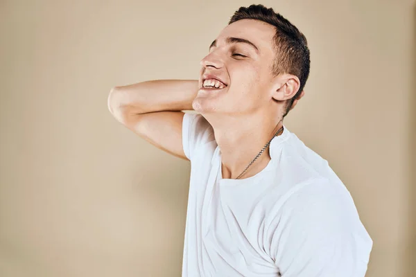 Emotional man white t-shirt gestures with hands lifestyle beige background — Stock Photo, Image