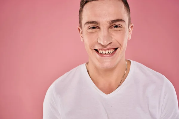 Homem alegre em branco t-shirt sorrir emoções close-up estúdio de fundo rosa — Fotografia de Stock