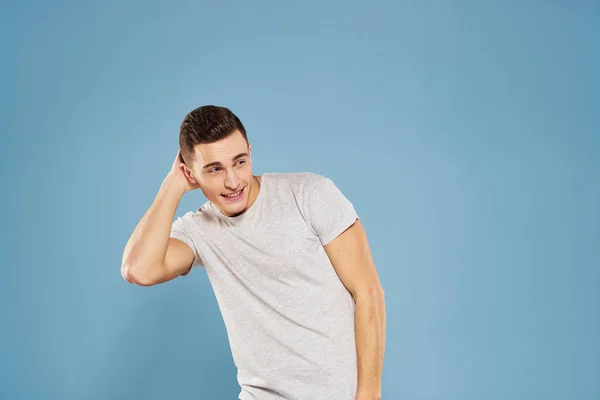 Uomo allegro in una t-shirt bianca gesticolando con le mani emozioni sfondo blu — Foto Stock