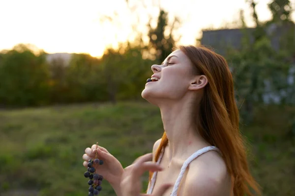 Woman with grapes in her hands outdoors portrait close-up — Stock Photo, Image