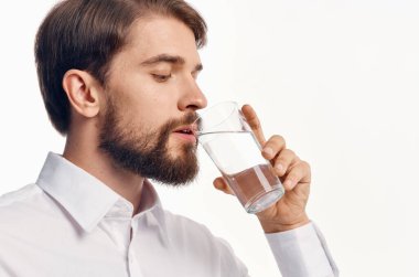 Bir bardak su içen bir adamın portresi serinletici hafif arka plan gömleği modeli.