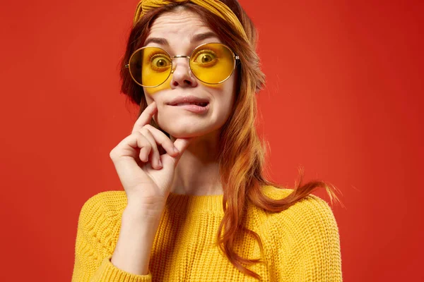 Mulher emocional alegre com óculos camisola amarela close-up fundo vermelho — Fotografia de Stock